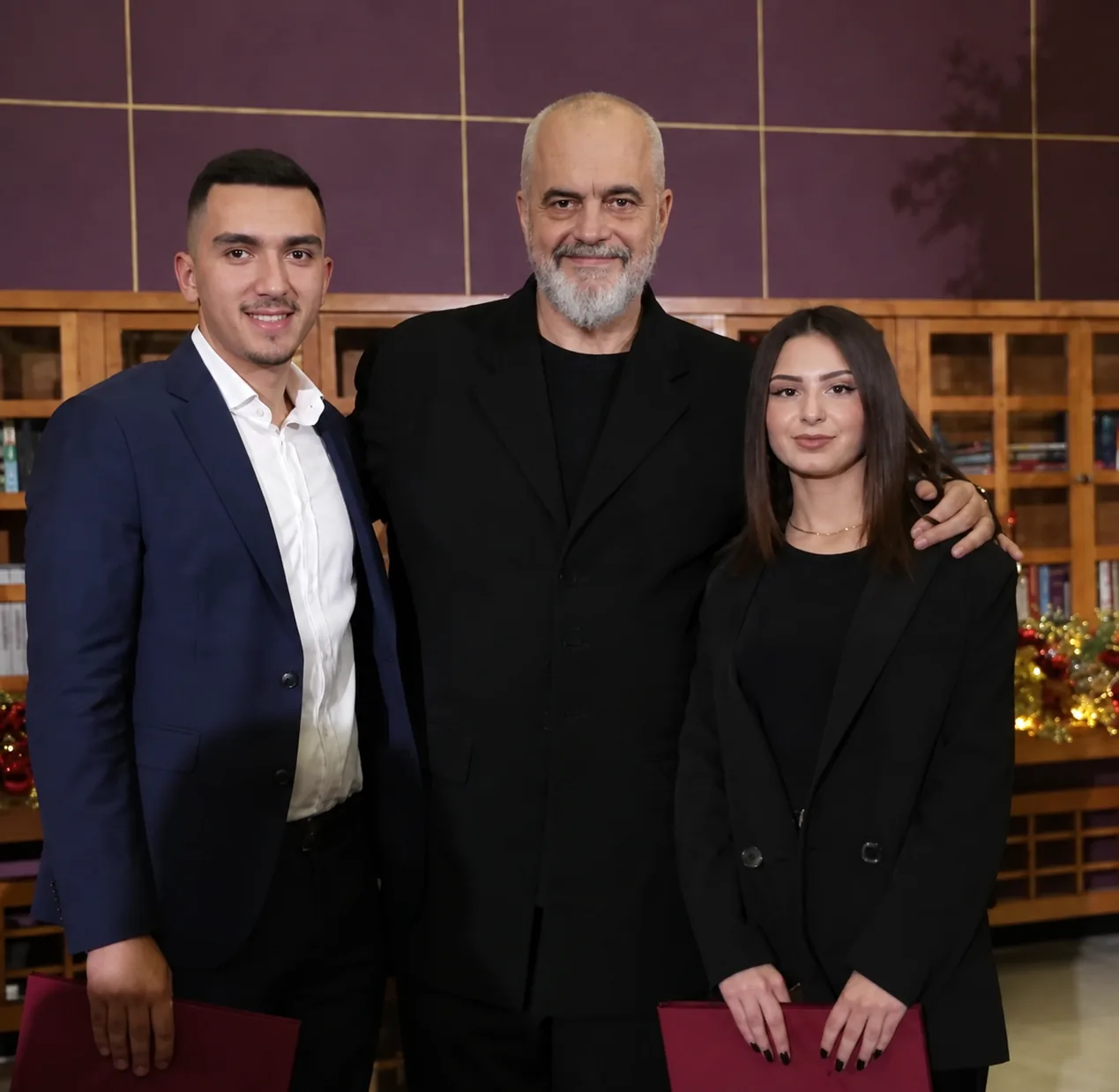 Dy nxënës të shkollës me medalje, me mirënjohjet në dorë.